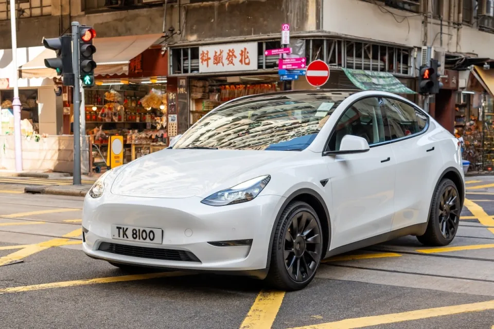 White Tesla sedan on street in Hong Kong.